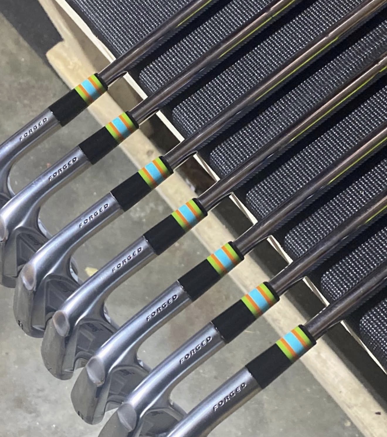 Black-finish forged irons with green, orange and blue rainbow striped ferrules